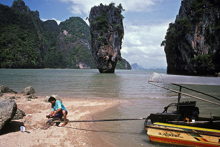 Homme réparant son hélice de hors-bord sur fond d'île Kha Tapu (James Bond, l'homme au pistolet d'or) - Thaïlande - Pukhet - décembre 1992 - Maritime